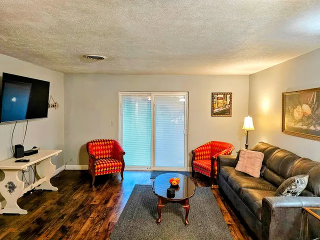 a living room with furniture a flat screen tv and gym equipment