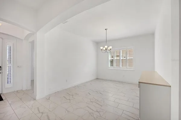 a view of kitchen with stainless steel appliances refrigerator oven and white cabinets with wooden floor