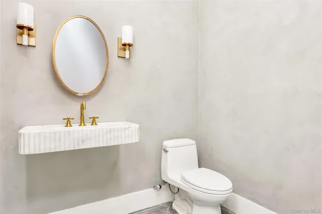 a bathroom with a toilet sink and mirror