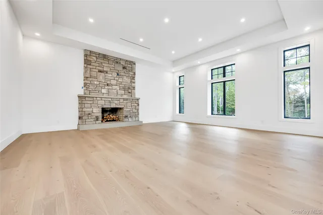 an empty room with windows and fireplace