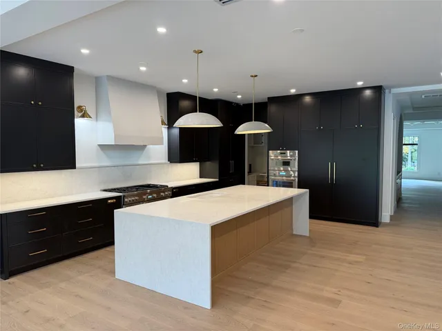 a large kitchen with stainless steel appliances a large counter top