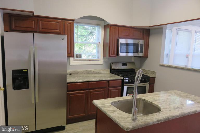3819 Barrington Road Baltimore, MD 21215 - Photo 11 of 19 a kitchen with stainless steel appliances granite countertop a sink a refrigerator and a granite counter tops