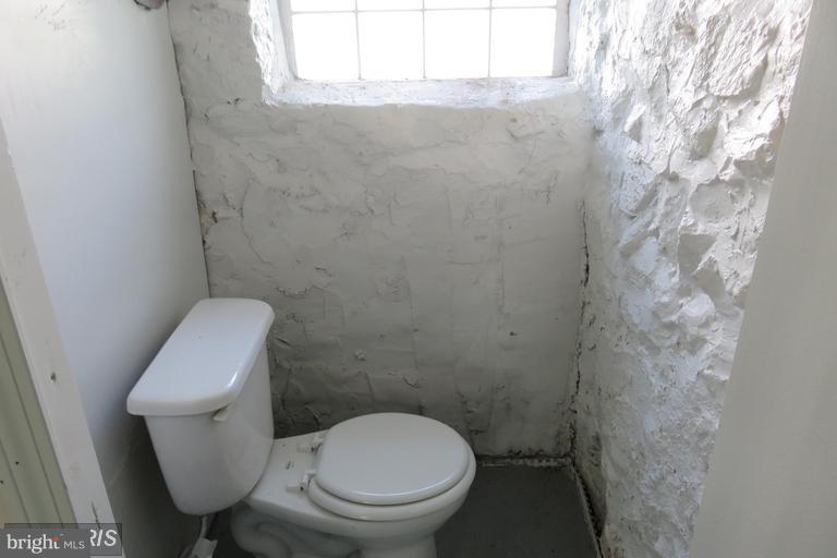 3819 Barrington Road Baltimore, MD 21215 - Photo 18 of 19 a white toilet sitting next to a shower curtain