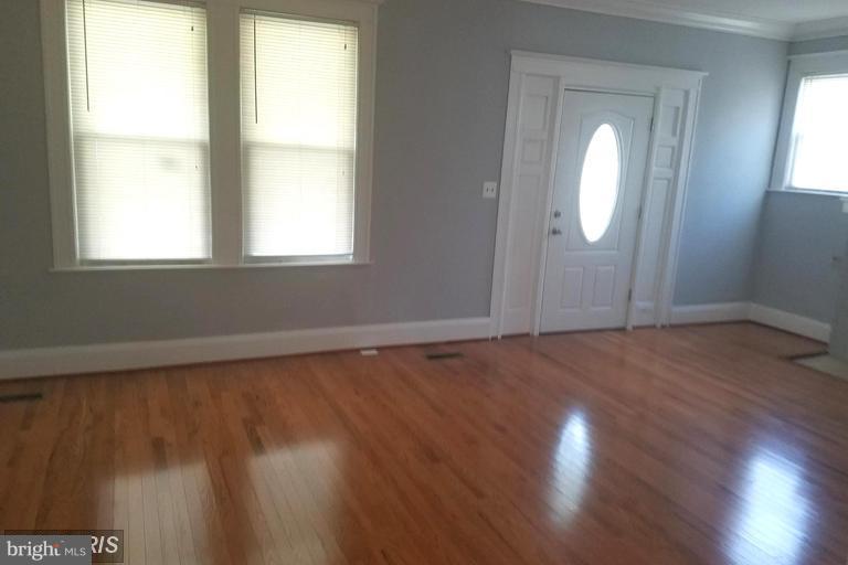 3819 Barrington Road Baltimore, MD 21215 - Photo 5 of 19 an empty room with wooden floor and windows
