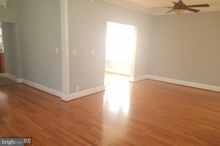 3819 Barrington Road Baltimore, MD 21215 - Photo 6 of 19 an empty room with wooden floor closet and windows