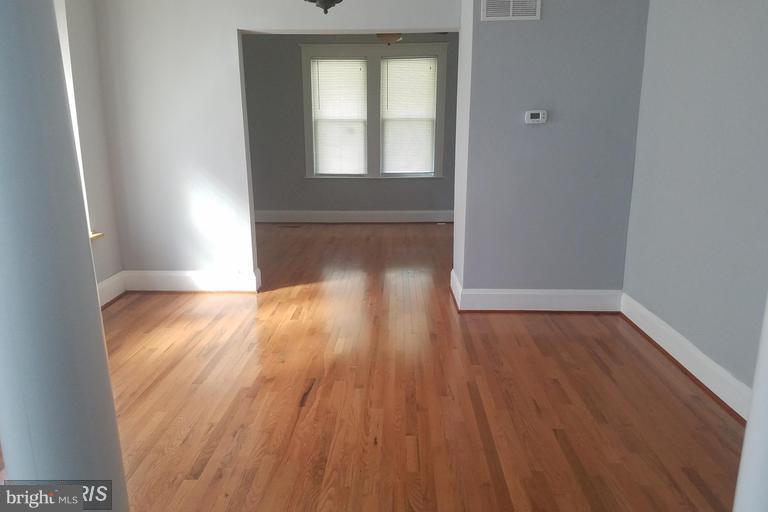 3819 Barrington Road Baltimore, MD 21215 - Photo 9 of 19 an empty room with wooden floor and windows