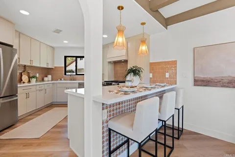 a kitchen with kitchen island a stove a table and chairs in it