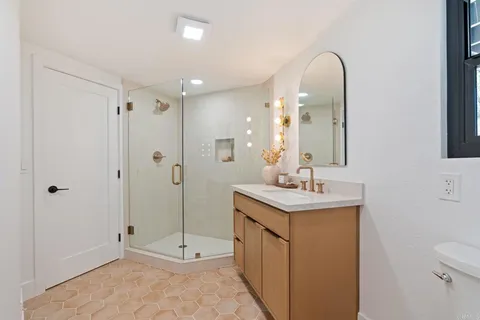 a bathroom with a sink a toilet and shower