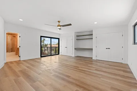 a view of an empty room with a window and a kitchen
