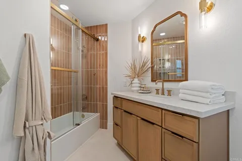 a bathroom with a tub sink and mirror