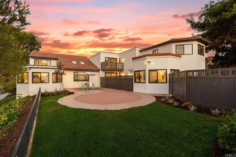 a front view of a house with a yard and trees