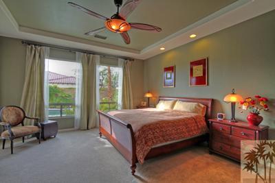 81129 Soaring Hawk Court Indio, CA 92201 - Photo 18 of 25 a bedroom with a bed and a chandelier