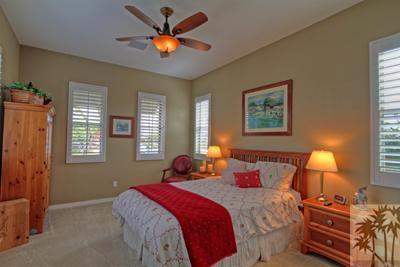 81129 Soaring Hawk Court Indio, CA 92201 - Photo 20 of 25 a bedroom with a bed and a chandelier