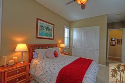 81129 Soaring Hawk Court Indio, CA 92201 - Photo 21 of 25 a bedroom with a bed and a lamp