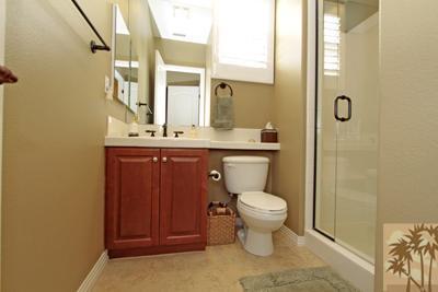 81129 Soaring Hawk Court Indio, CA 92201 - Photo 23 of 25 a bathroom with a toilet a sink and mirror