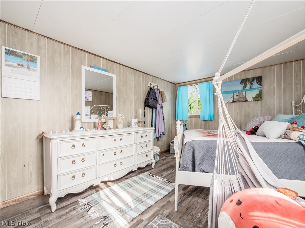 4182 Tooms Road Cumberland, OH 43732 - Photo 20 of 37 Bedroom with wood-finish paneling and wood-finish flooring