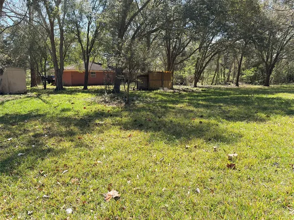 a view of a house with a big yard and large trees