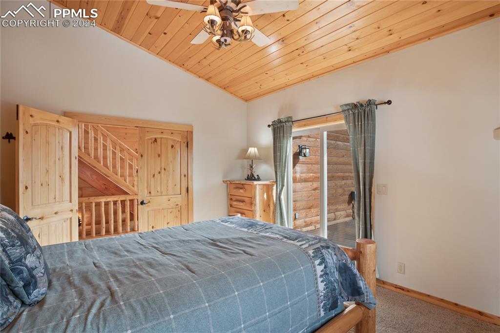 156 Paradiso Road Divide, CO 80814 - Photo 27 of 45 a bedroom with a large bed and a chandelier