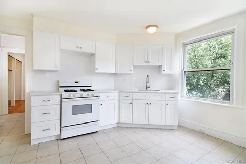 a kitchen with granite countertop white cabinets and white appliances