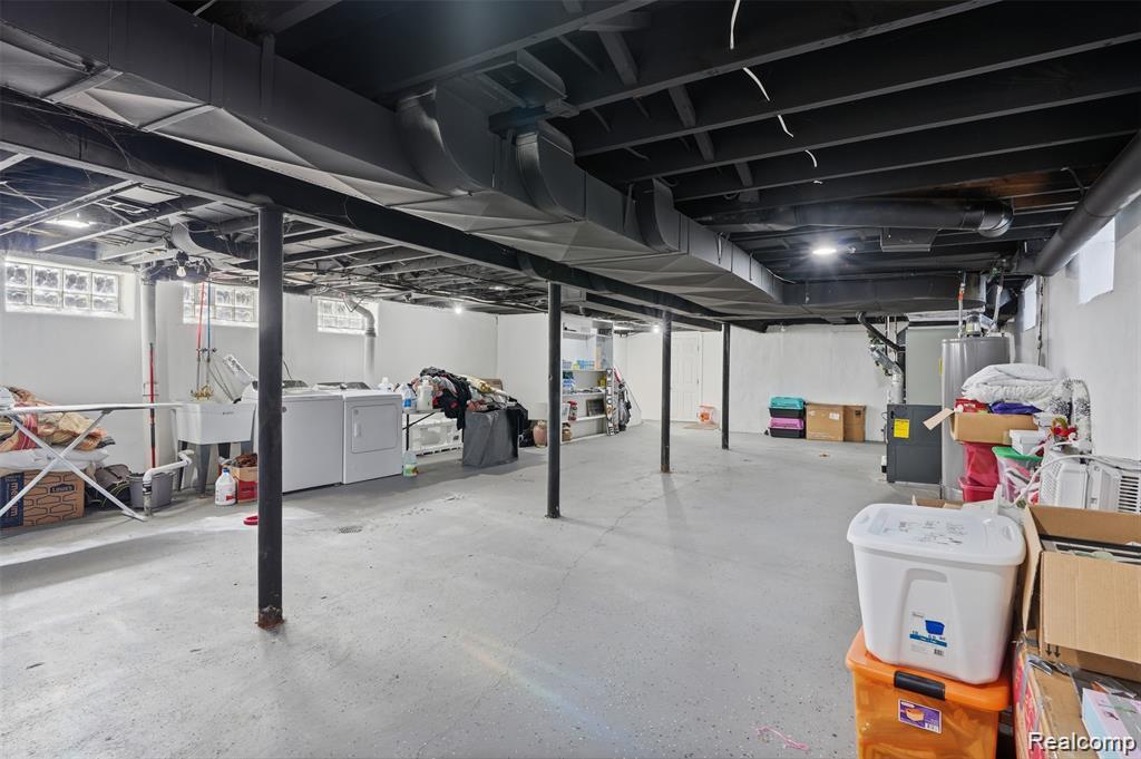 4612 Balfour Road Detroit, MI 48224 - Photo 17 of 20 Expansive lower level featuring a concrete floor, exposed painted ceiling joists, and utility area with laundry hookups and a utility sink