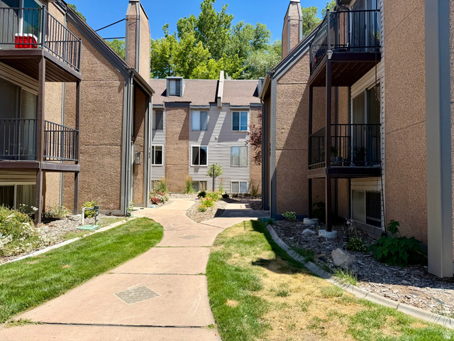 169 East 100 North, Unit B Logan, UT 84321 - Photo 8 of 11 Concrete walkway bordered by manicured lawns and landscaping