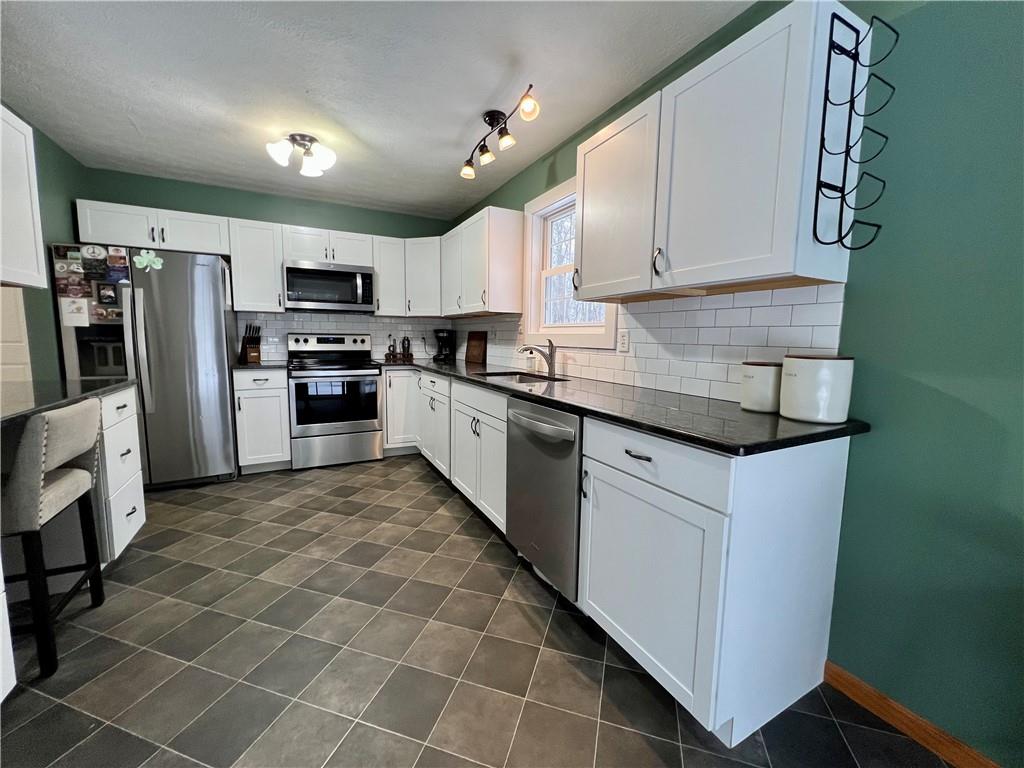 112 Old Forge Road Slippery Rock, PA 16057 - Photo 16 of 30 a kitchen with stainless steel appliances granite countertop a sink a stove a refrigerator cabinets and a microwave