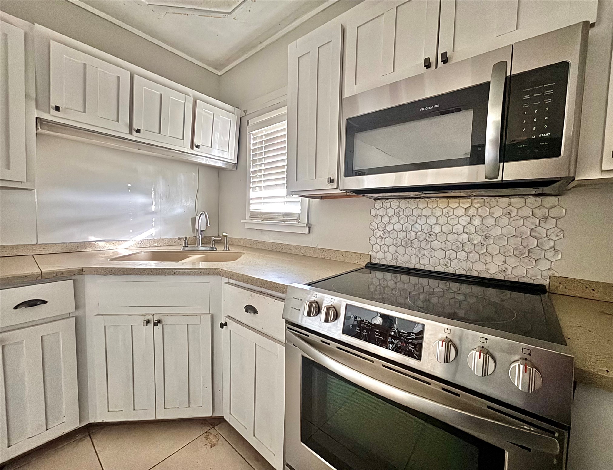 408 West Elder Street Colmesneil, TX 75938 - Photo 15 of 28 a kitchen with granite countertop a stove microwave and sink