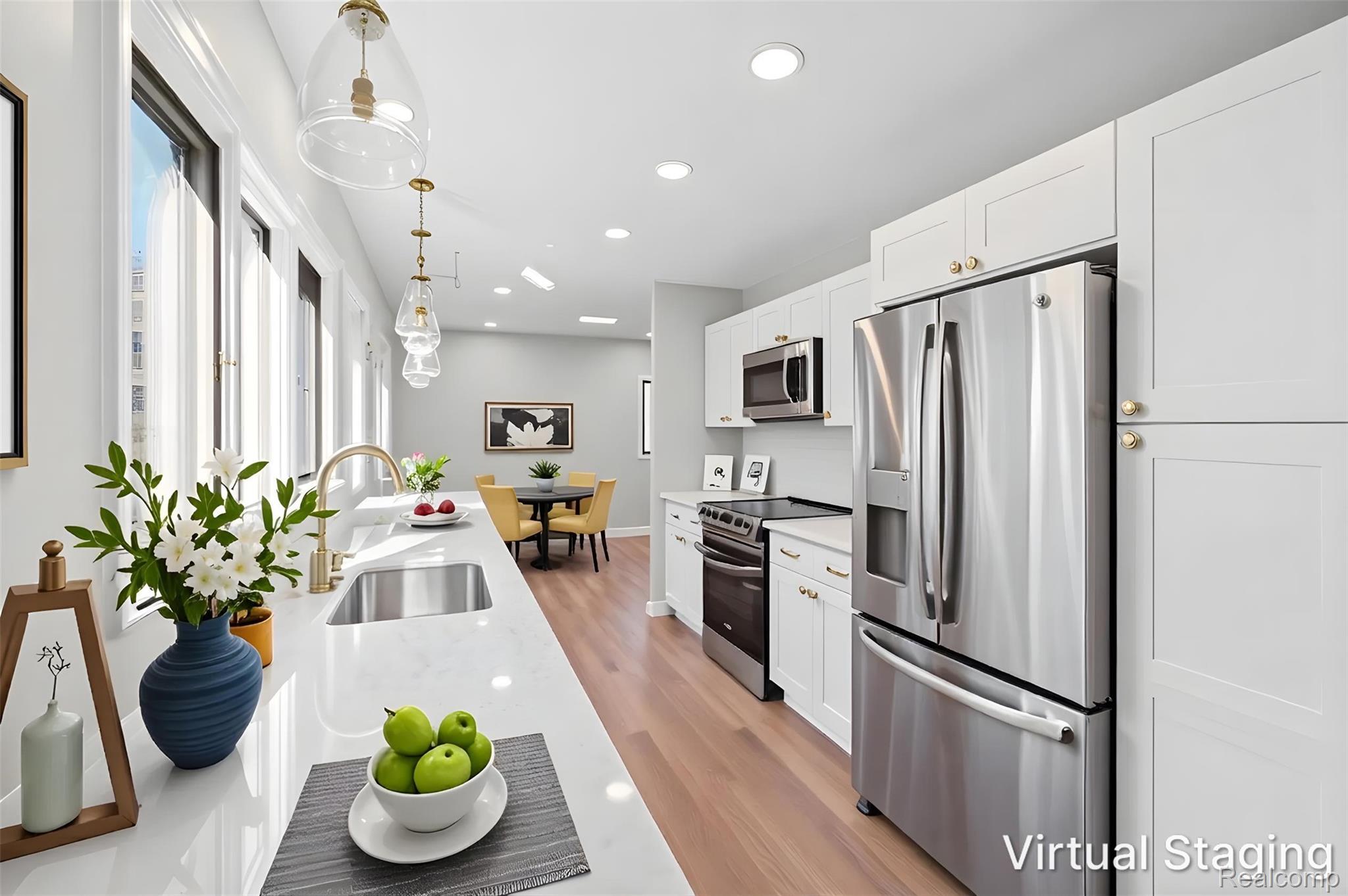 6273 Cold Spring Trail Grand Blanc, MI 48439 - Photo 19 of 48 Modern kitchen featuring white shaker cabinetry, stainless steel appliances, a large single-basin sink with a gold-tone faucet, and pendant lighting