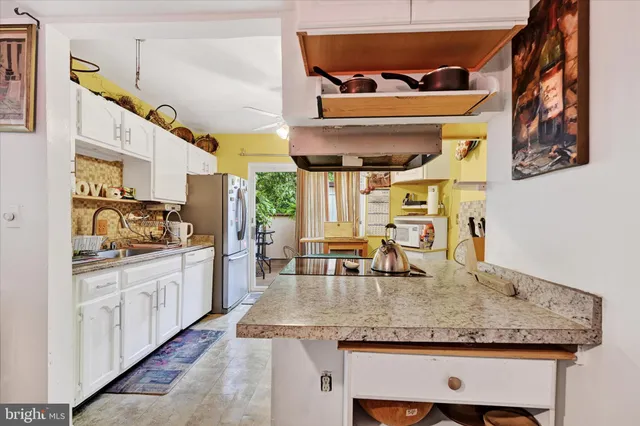 a kitchen with stainless steel appliances granite countertop a sink and a refrigerator