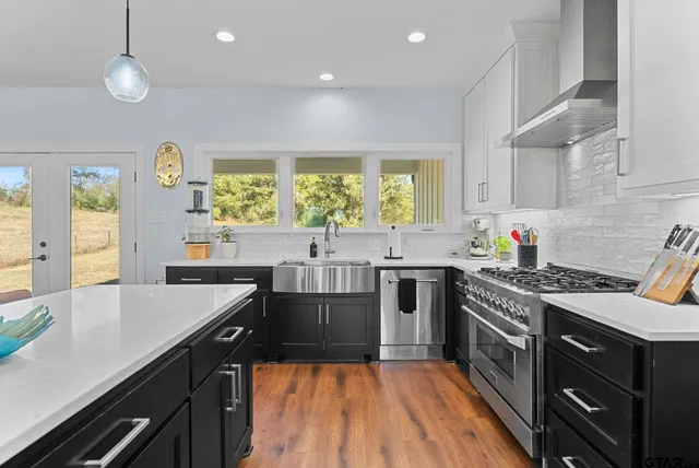 a kitchen with a stove a sink a window and dining table