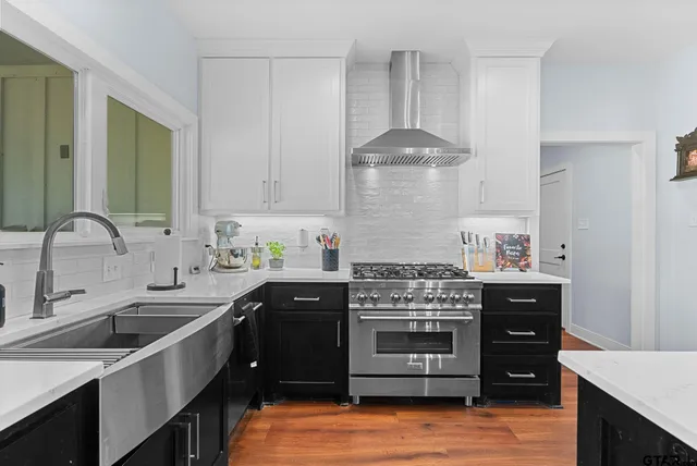 a kitchen with stainless steel appliances granite countertop a sink stove and cabinets