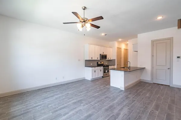 a view of a kitchen with wooden floor and a window