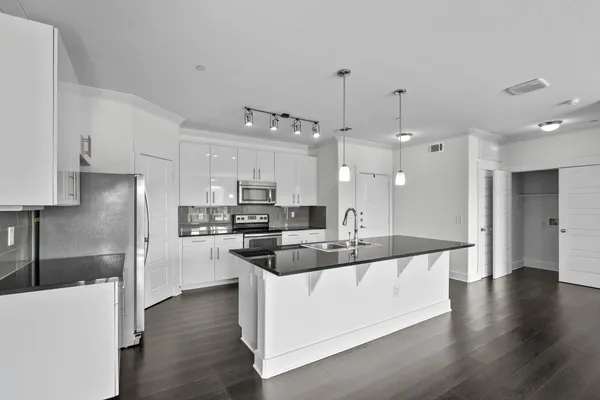 a kitchen with stainless steel appliances kitchen island a refrigerator a stove a sink and a microwave