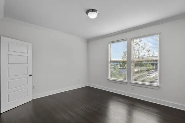 a large kitchen with kitchen island a stove a sink dishwasher a refrigerator and white cabinets with wooden floor