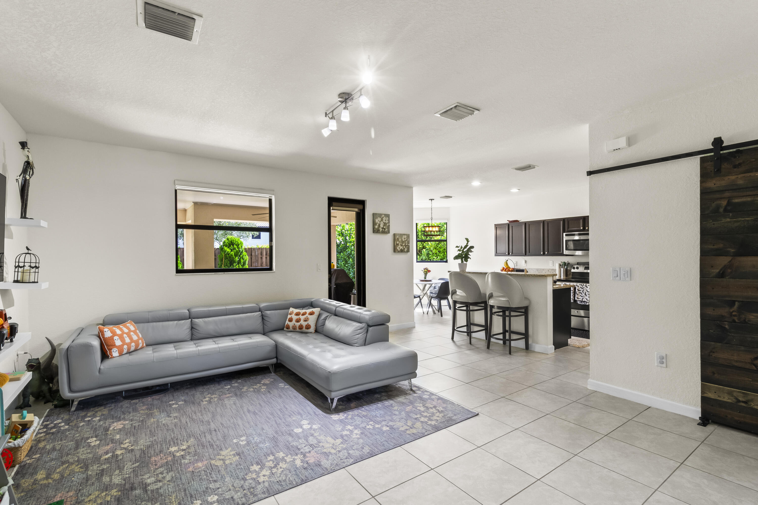 11823 Southwest 151st Place Miami, FL 33196 - Photo 12 of 53 a living room with furniture and a dining table with kitchen view
