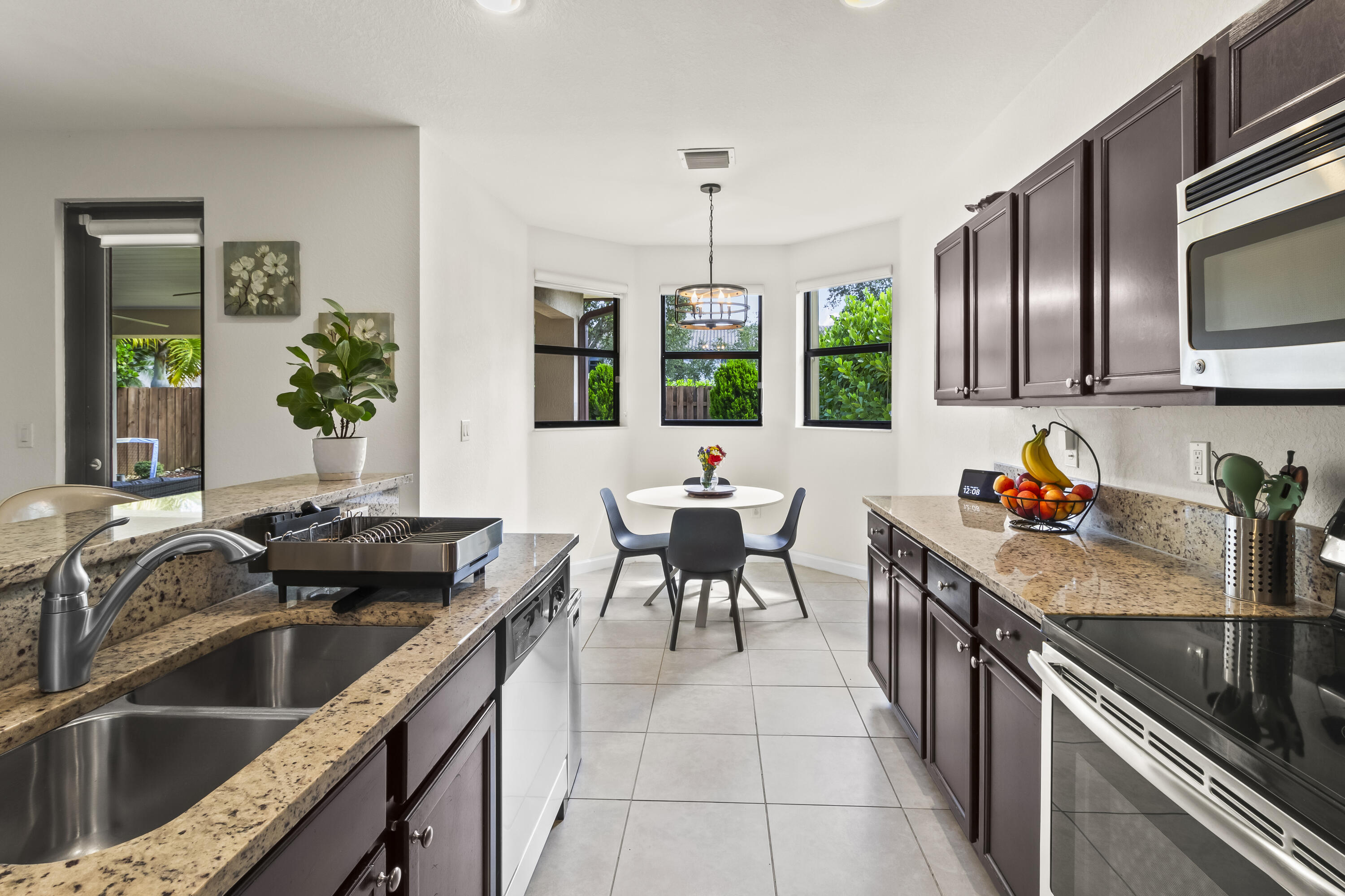 11823 Southwest 151st Place Miami, FL 33196 - Photo 17 of 53 a kitchen with granite countertop a sink and a stove top oven with wooden floor