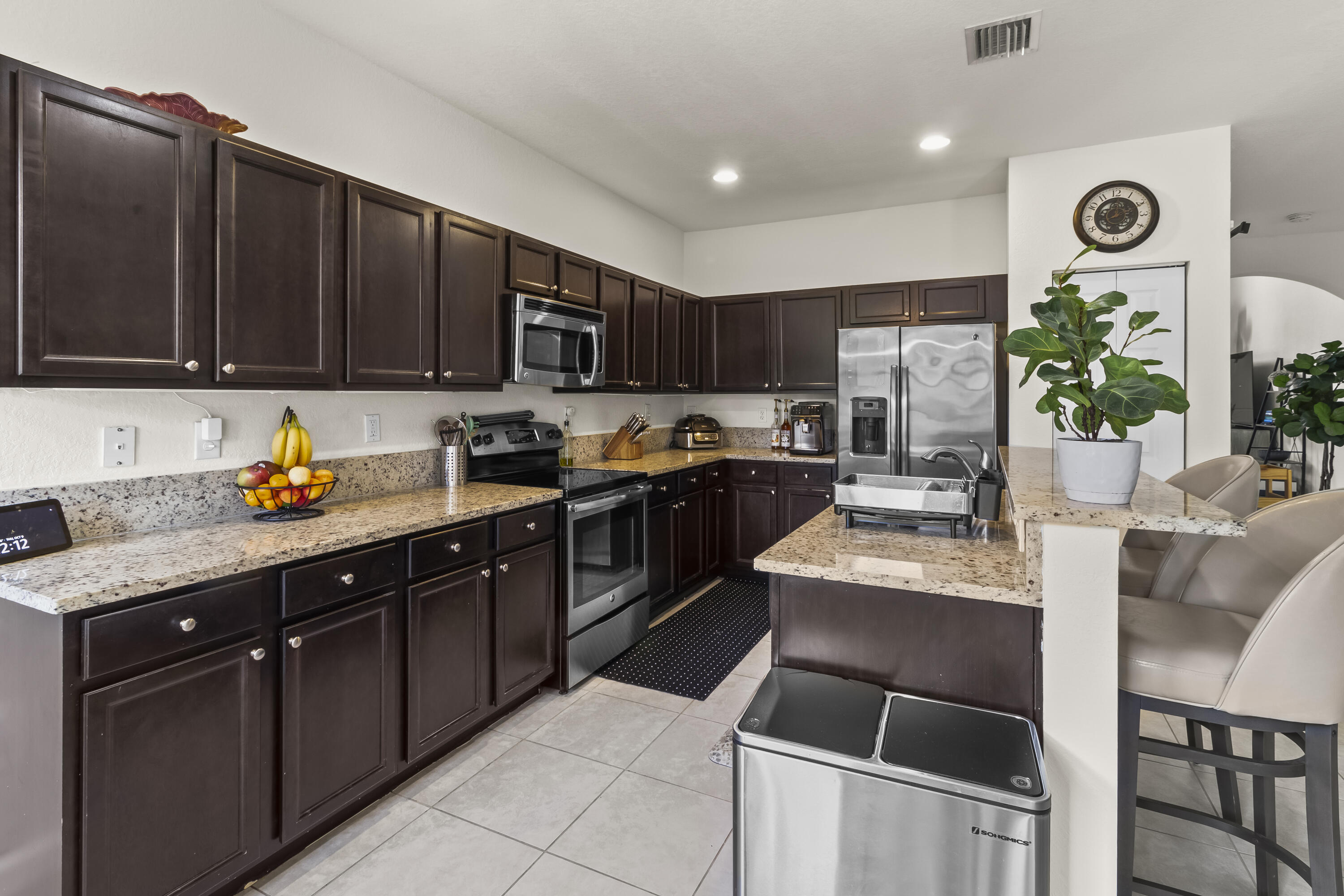 11823 Southwest 151st Place Miami, FL 33196 - Photo 19 of 53 a kitchen with granite countertop a stove top oven a sink a table and chairs