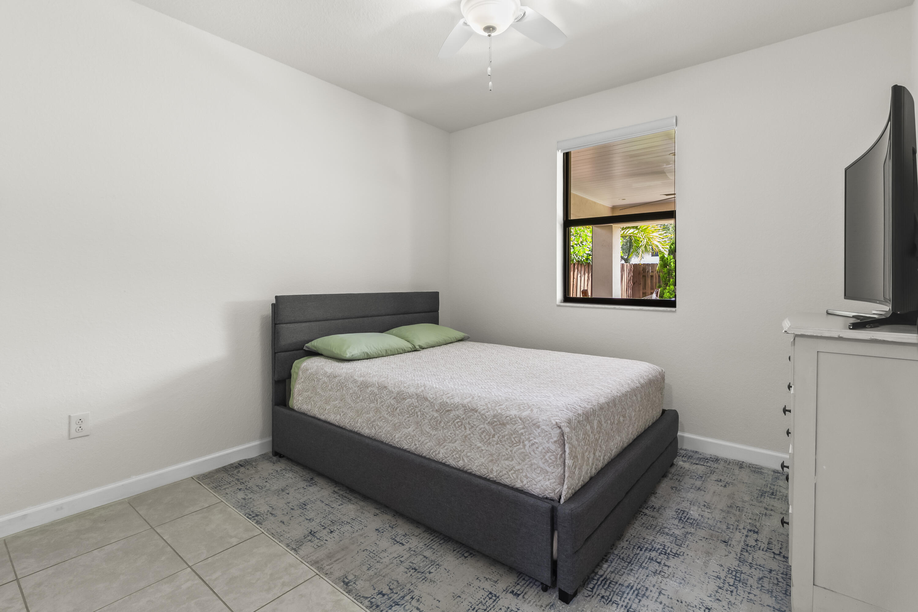 11823 Southwest 151st Place Miami, FL 33196 - Photo 21 of 53 a bedroom with a bed and a flat tv screen on a dresser