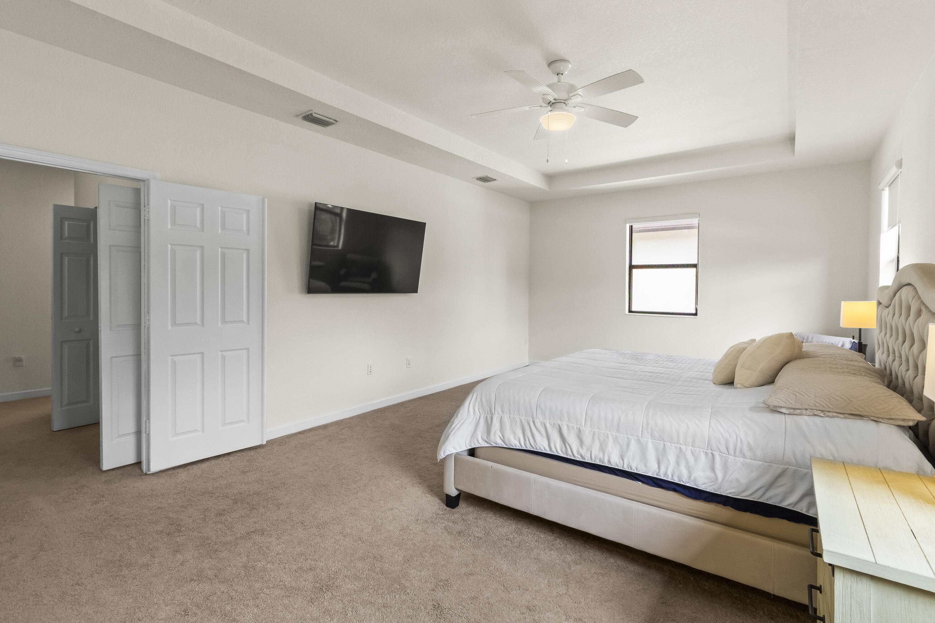 11823 Southwest 151st Place Miami, FL 33196 - Photo 31 of 53 a bedroom with a bed a window and a flat screen tv