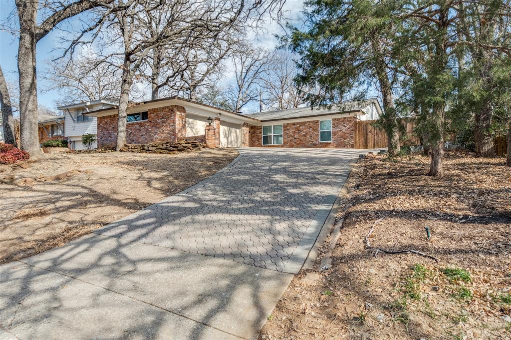 1136 Brookside Drive Hurst, TX 76053 - Photo 1 of 1 a front view of a house with a yard covered with trees
