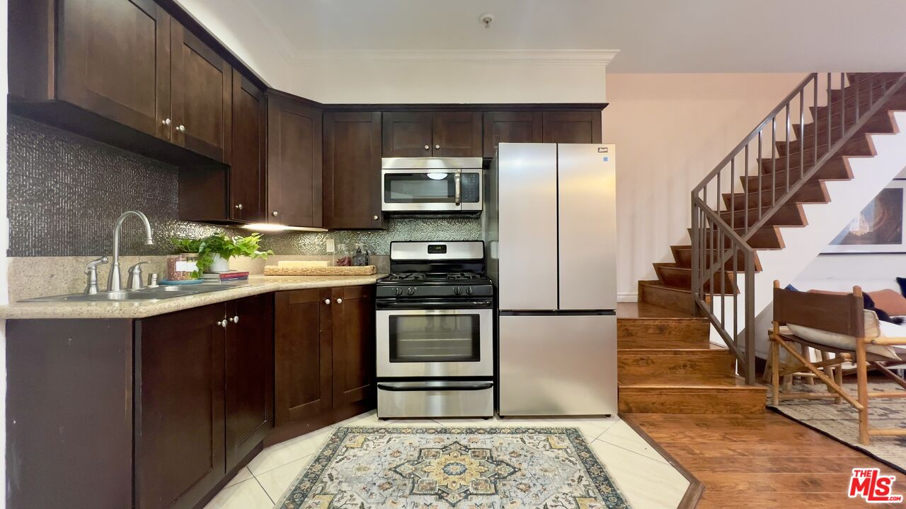 5633 Carlton Way, Unit 203 Los Angeles, CA 90028 - Photo 4 of 15 a kitchen with stainless steel appliances granite countertop a refrigerator stove and sink
