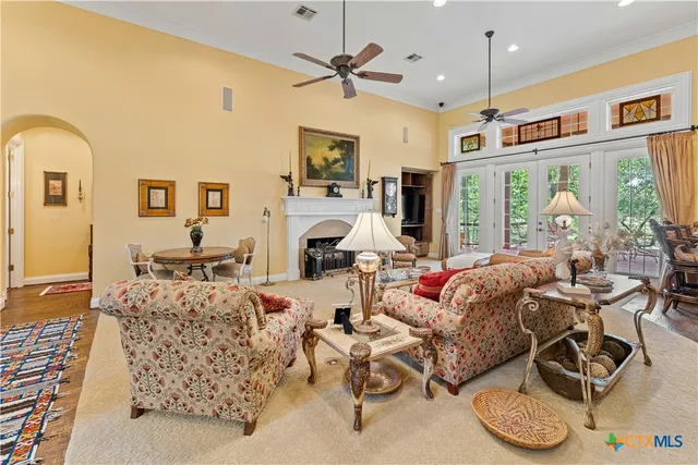 a living room with furniture a fireplace and a chandelier