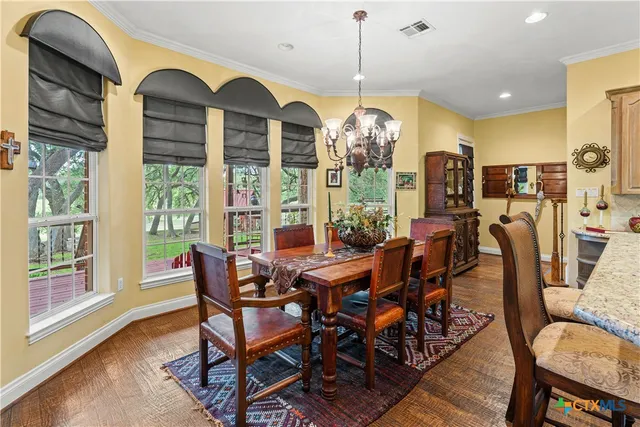 a view of a dining room with furniture wooden floor and chandelier