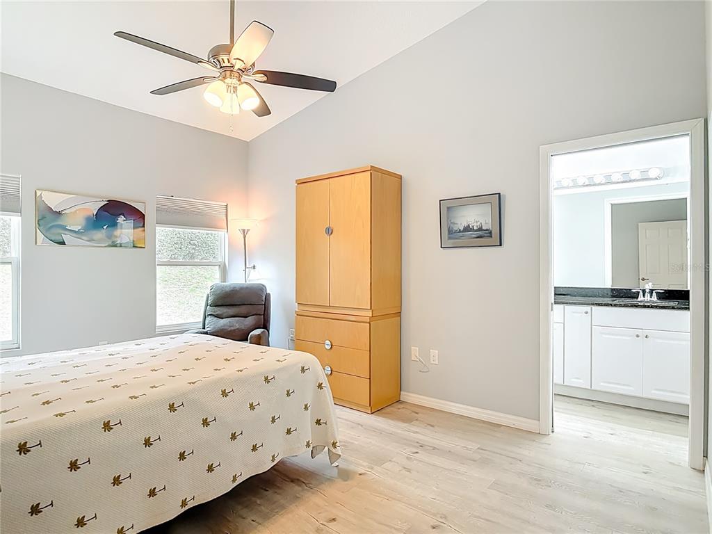 202 Walter Stevens Way DeLand, FL 32724 - Photo 16 of 34 a bedroom with a bed and a chandelier