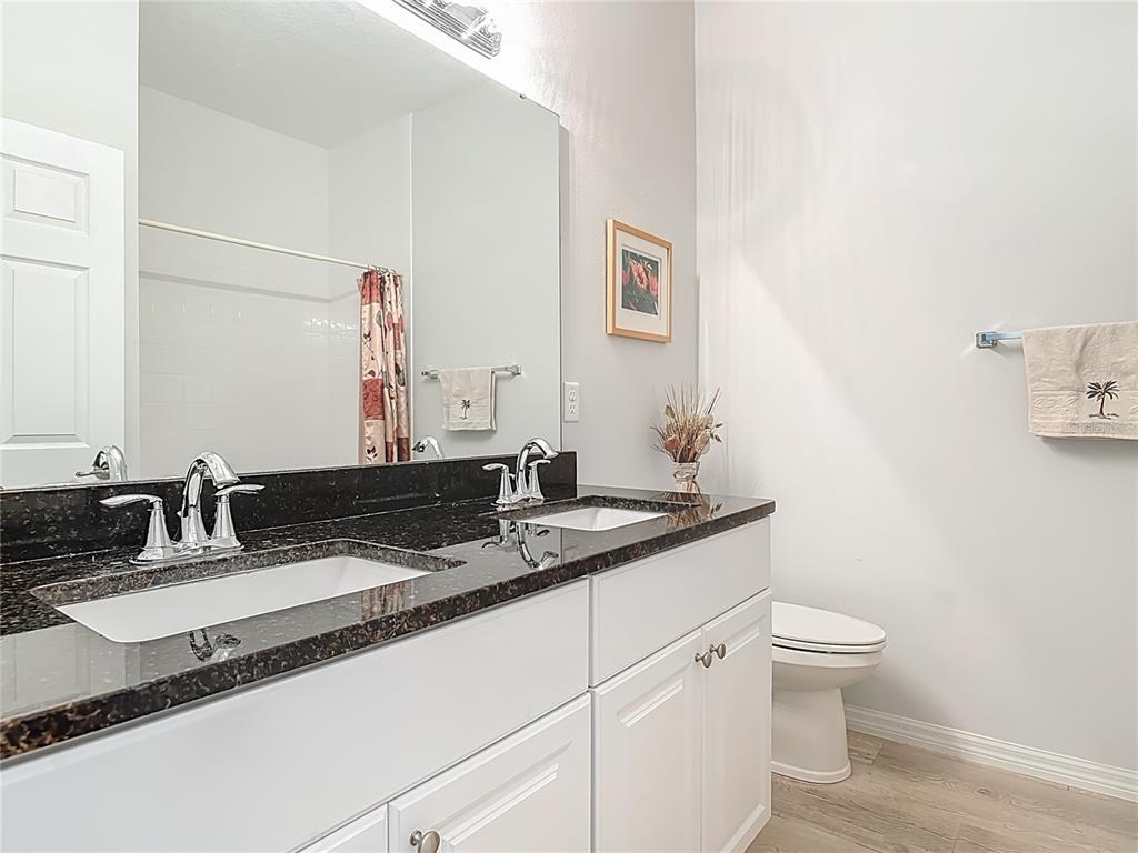 202 Walter Stevens Way DeLand, FL 32724 - Photo 22 of 34 a bathroom with a granite countertop sink and a mirror