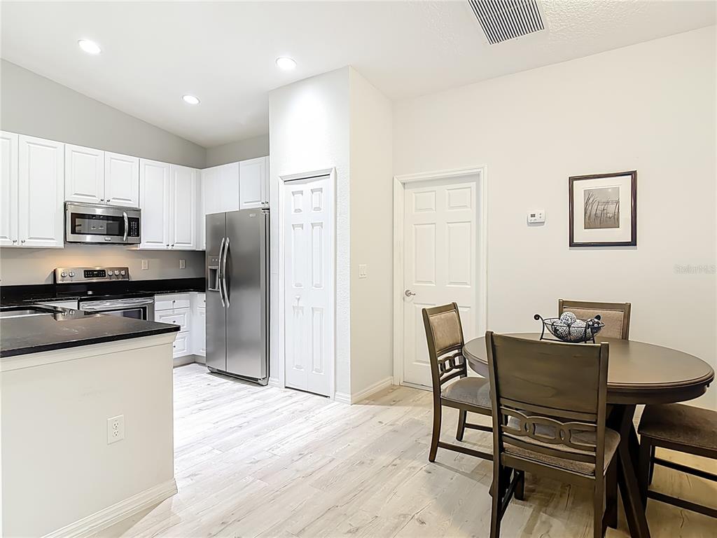 202 Walter Stevens Way DeLand, FL 32724 - Photo 6 of 34 a kitchen with stainless steel appliances a refrigerator a stove a dining table and chairs