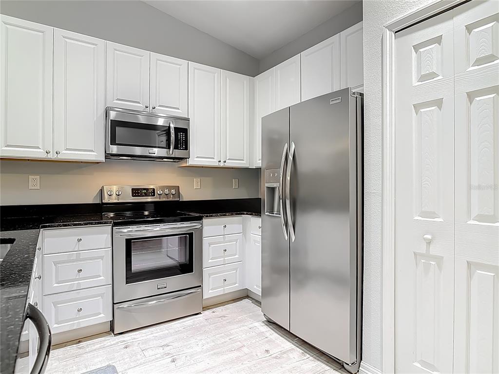 202 Walter Stevens Way DeLand, FL 32724 - Photo 10 of 34 a kitchen with stainless steel appliances granite countertop a refrigerator a stove and a sink with wooden floor