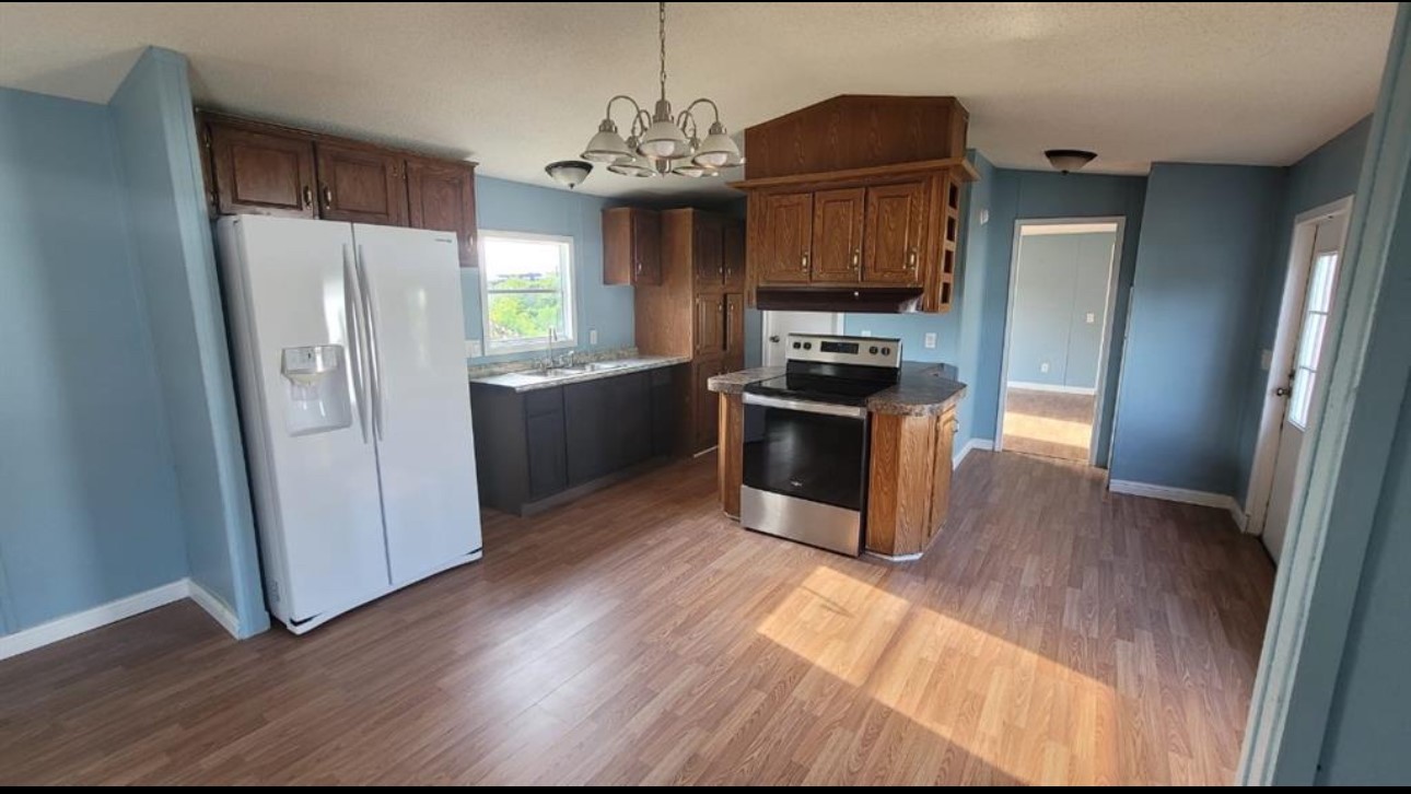 1403 Old Greens Road Houston, TX 77032 - Photo 12 of 19 a kitchen with granite countertop stainless steel appliances a refrigerator cabinets and wooden floor