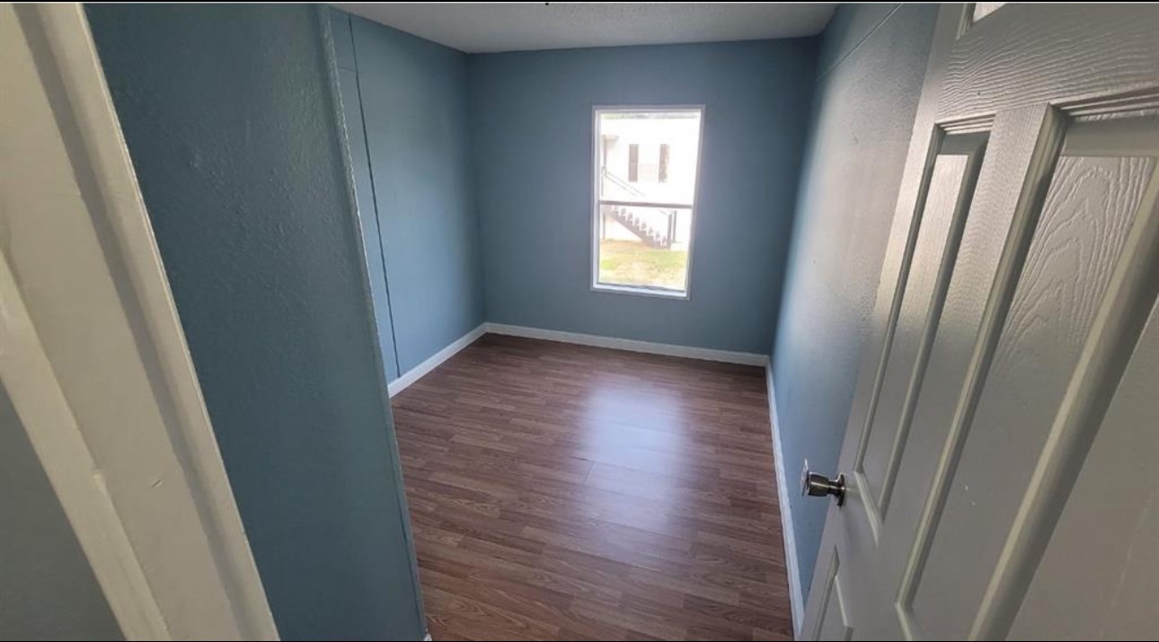1403 Old Greens Road Houston, TX 77032 - Photo 3 of 19 an empty room with wooden floor and windows