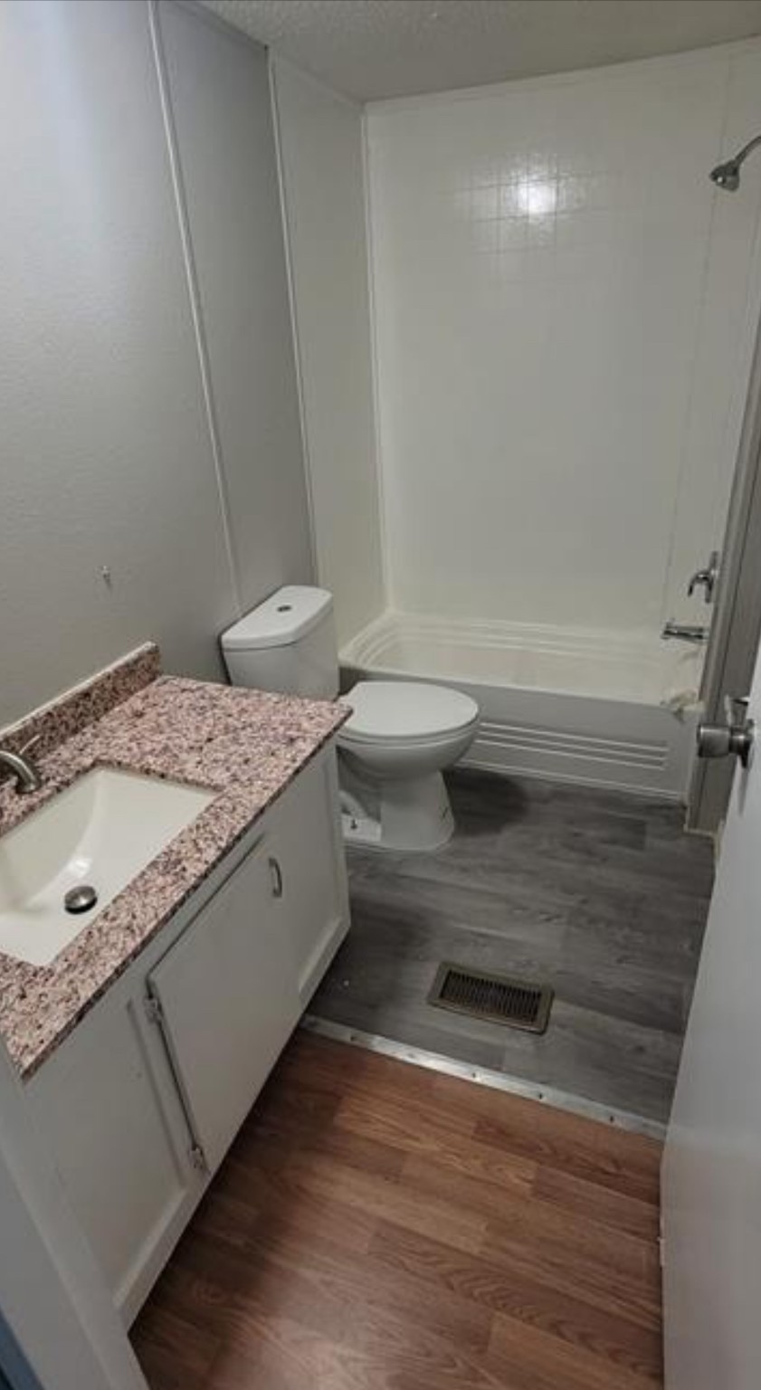 1403 Old Greens Road Houston, TX 77032 - Photo 8 of 19 a bathroom with a granite countertop sink a toilet and bathtub